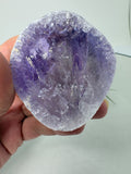 Amatista visión ahumada de gran calidad, con tonos violetas, zonas transparentes y pequeños destellos arcoíris. Descúbrela en La Hada de las Piedras.