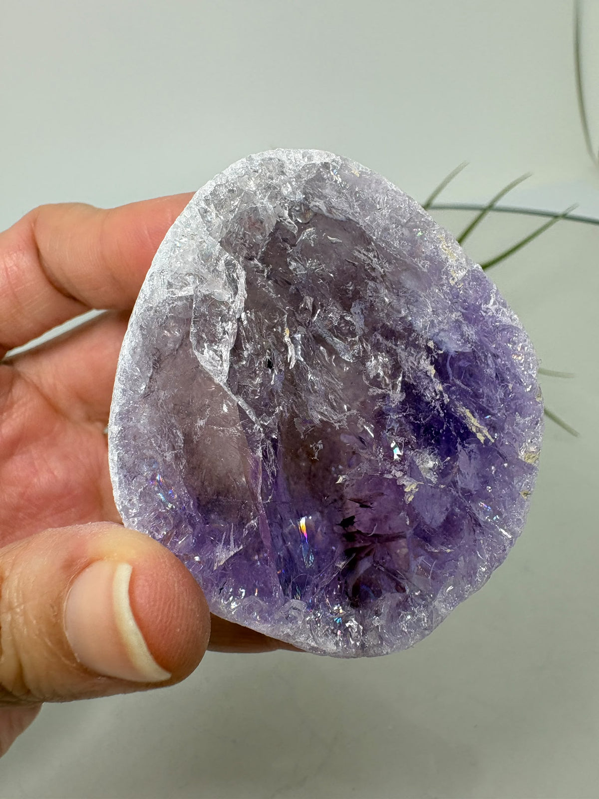 Amatista visión ahumada de gran calidad, con tonos violetas, zonas transparentes y pequeños destellos arcoíris. Descúbrela en La Hada de las Piedras.