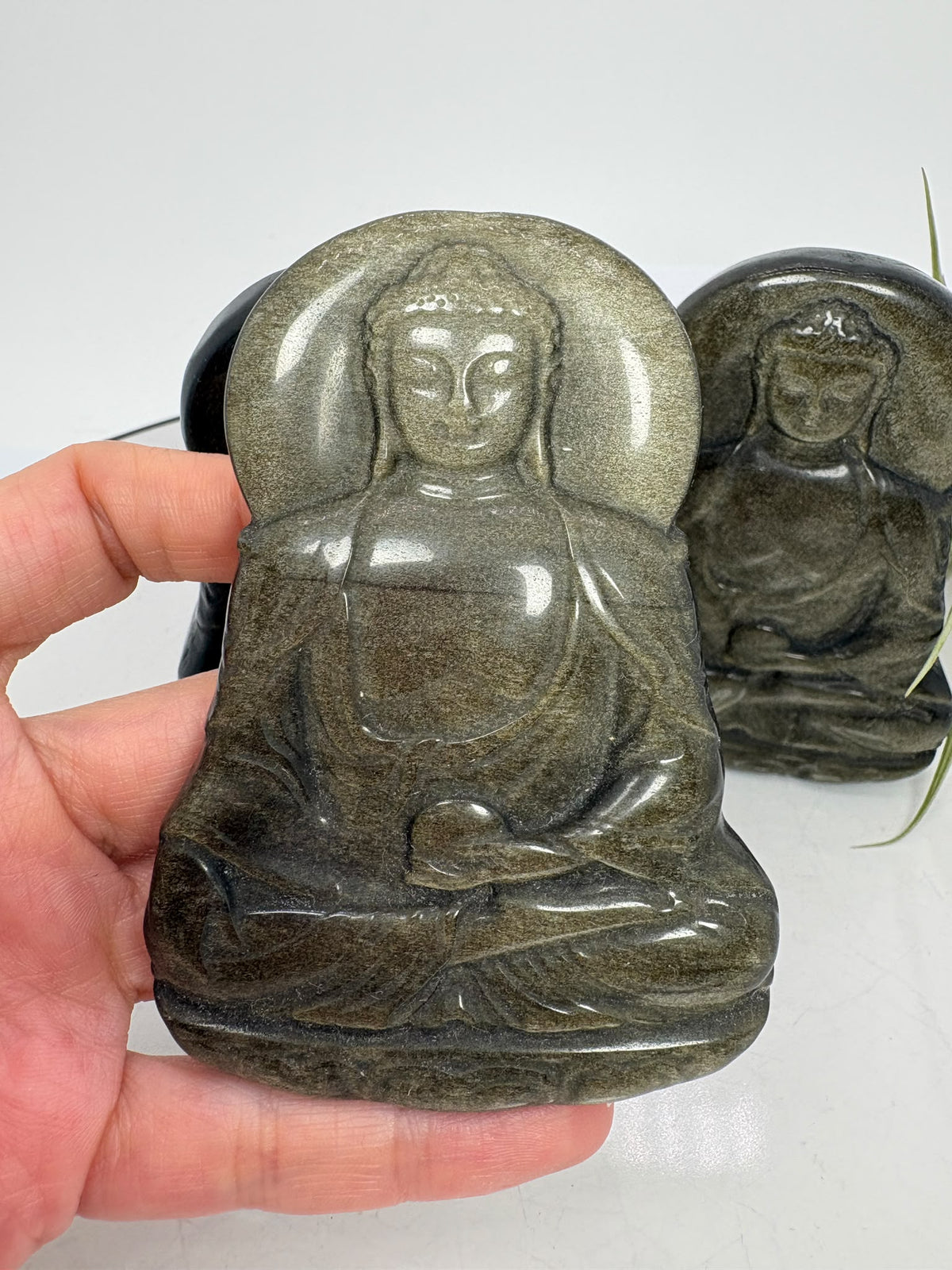 Buda de obsidiana plateada tallado a mano de 8,1 cm. Piezas escogidas con dedicación para regalar o meditar. Envío de una unidad aleatoria.