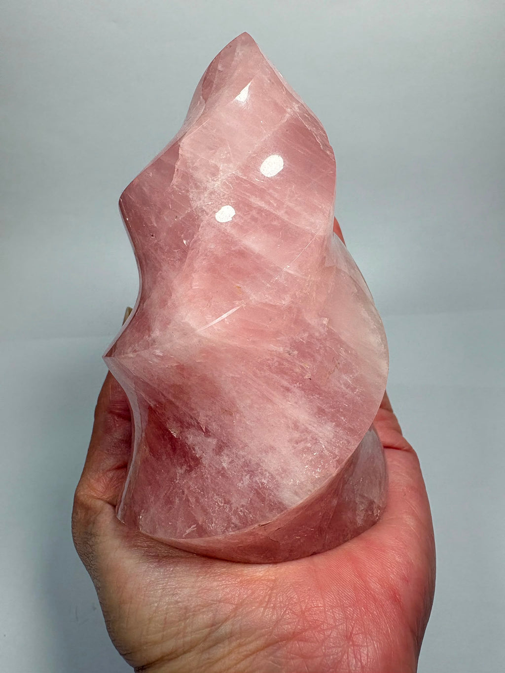 Llama de cuarzo rosa natural de alta calidad de 435 g. Pieza única con precioso color rosa, pulido brillante y unas medidas de 10,2 × 5,6 × 5,1 cm.