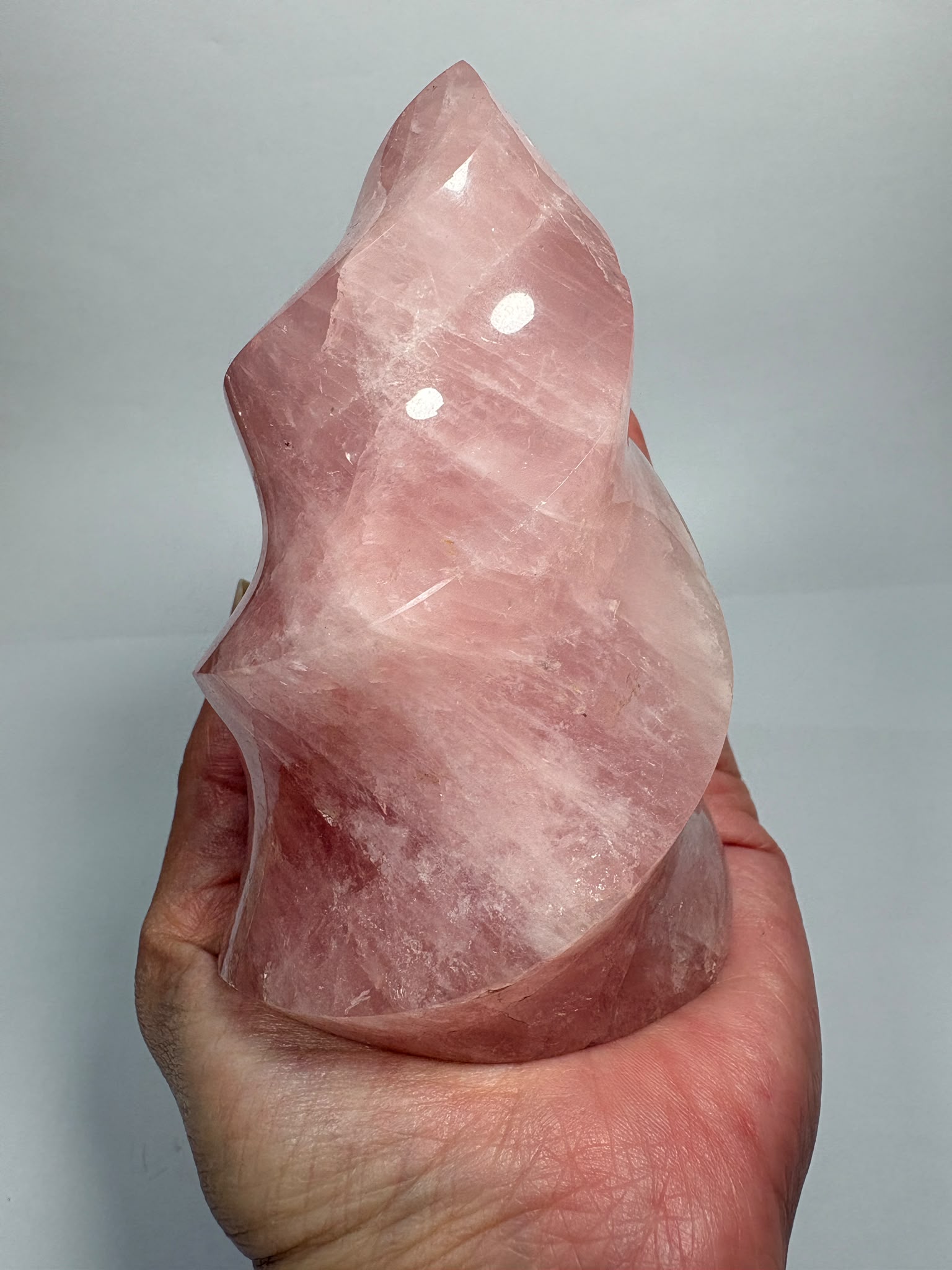 Llama de cuarzo rosa natural de alta calidad de 435 g. Pieza única con precioso color rosa, pulido brillante y unas medidas de 10,2 × 5,6 × 5,1 cm.