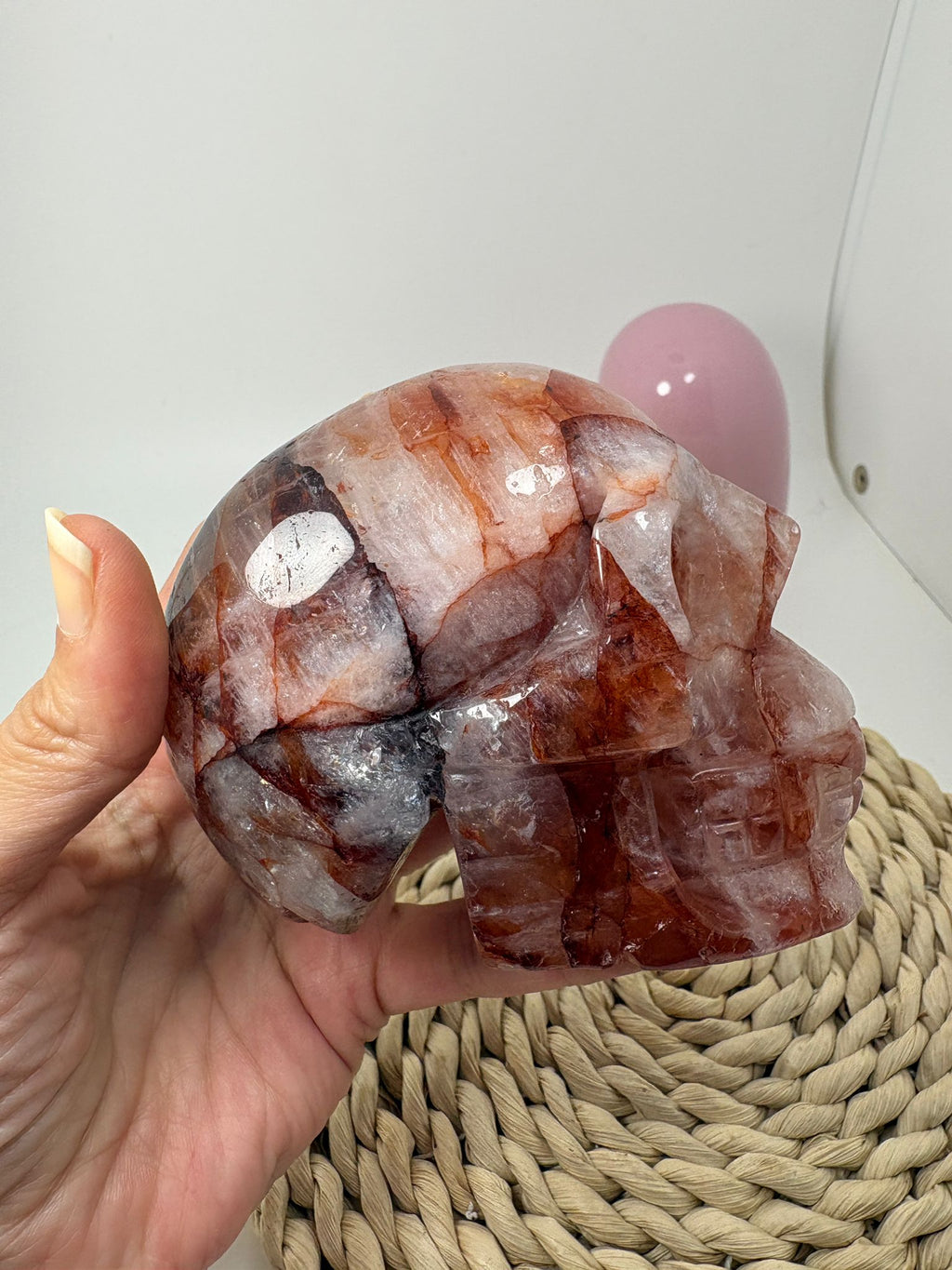 Calavera tallada en cuarzo fuego natural con preciosas inclusiones de hematite y arrastres de hierro que crean tonos rojizos y dibujos internos únicos.
