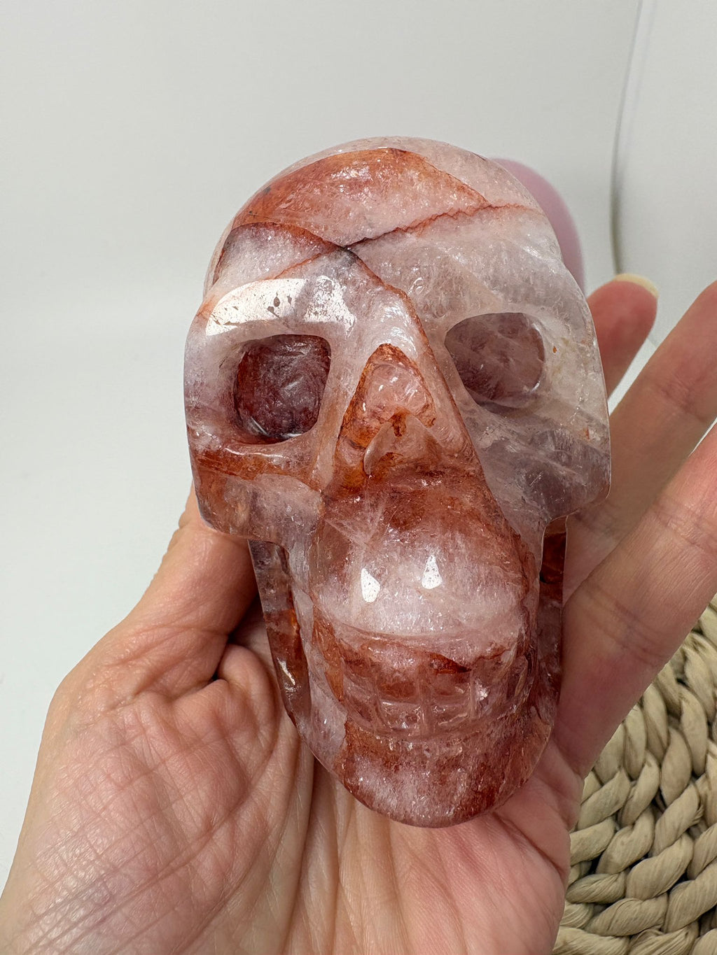Calavera tallada en cuarzo fuego natural con preciosas inclusiones de hematite y arrastres de hierro que crean tonos rojizos y dibujos internos únicos.