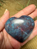 Corazón de cianita azul con rubí semipulido. El rubí presenta una intensa fluorescencia roja bajo la luz ultravioleta. Pieza única.
