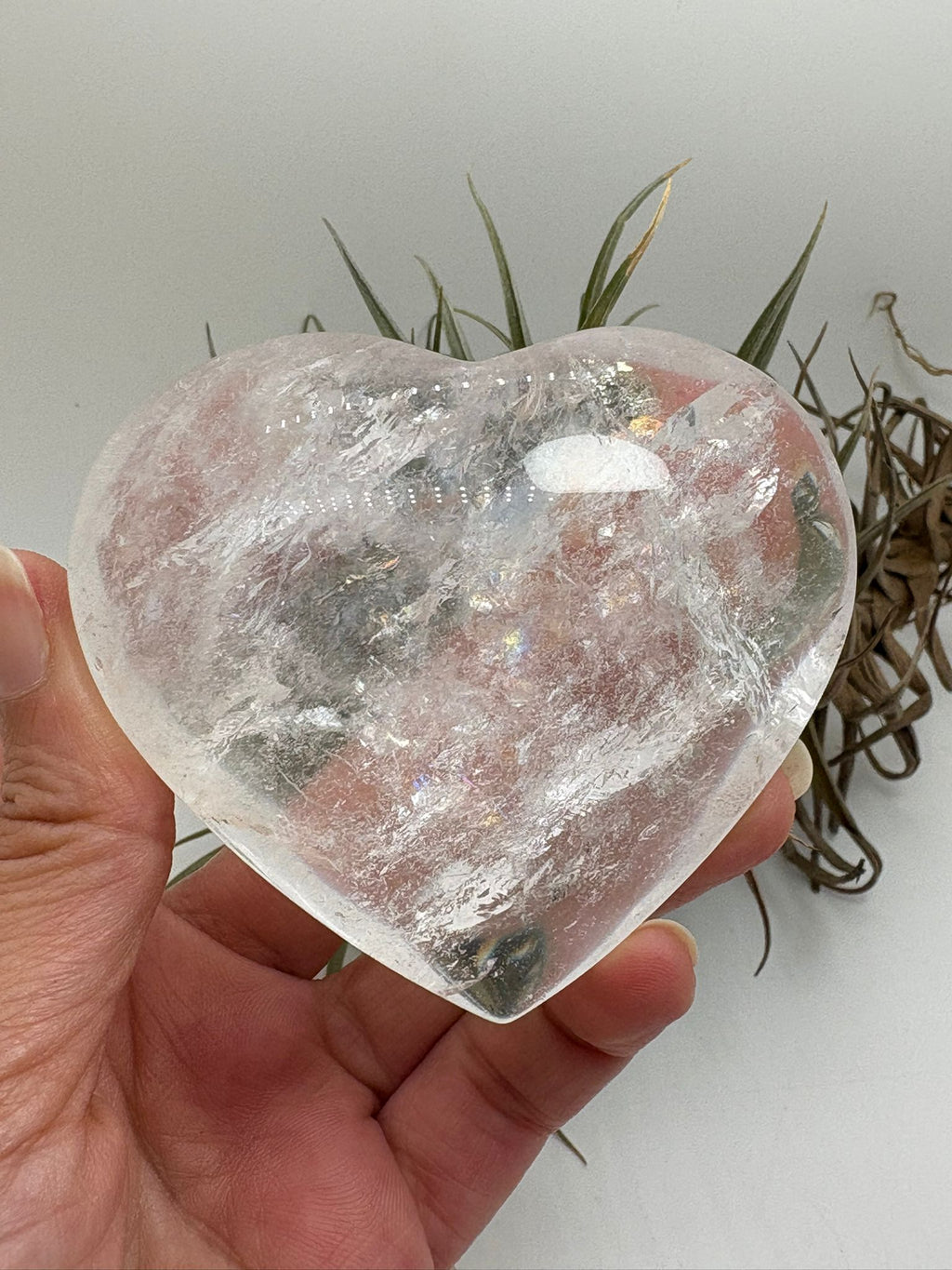 Corazón de cuarzo cristal transparente con preciosos reflejos arcoíris naturales en su interior. Una pieza pulida llena de luz y energía, ideal para decorar, meditar o trabajar la claridad mental y la armonía energética.