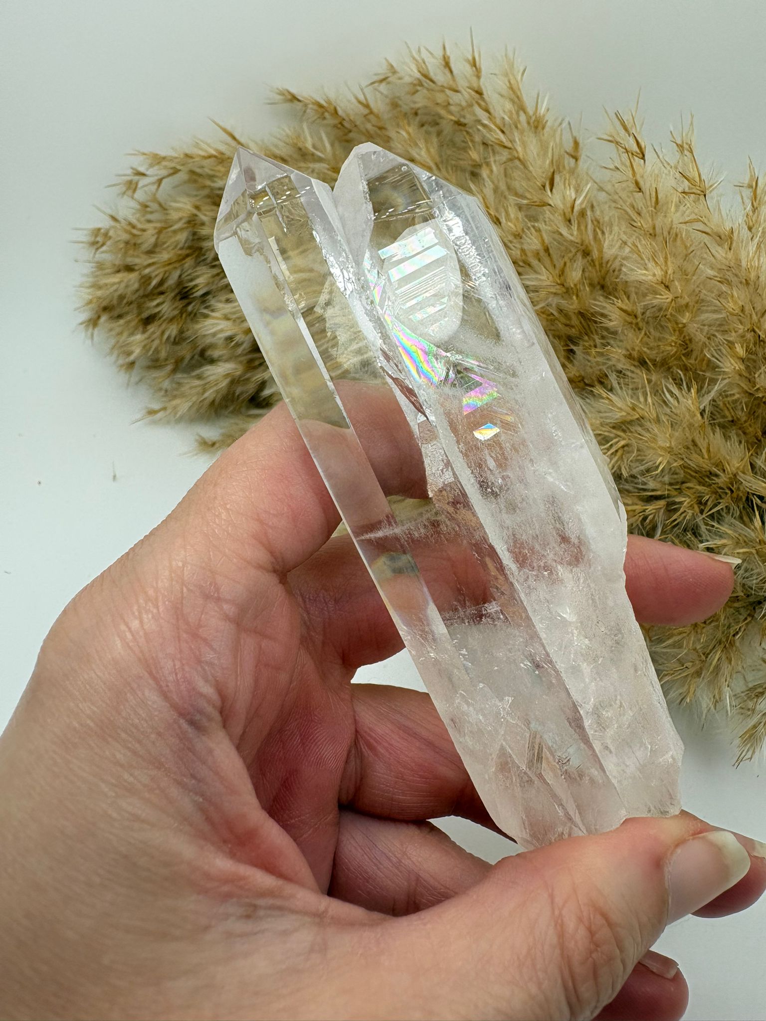 Cuarzo cristal natural pulido con zonas en bruto y arcoíris interno