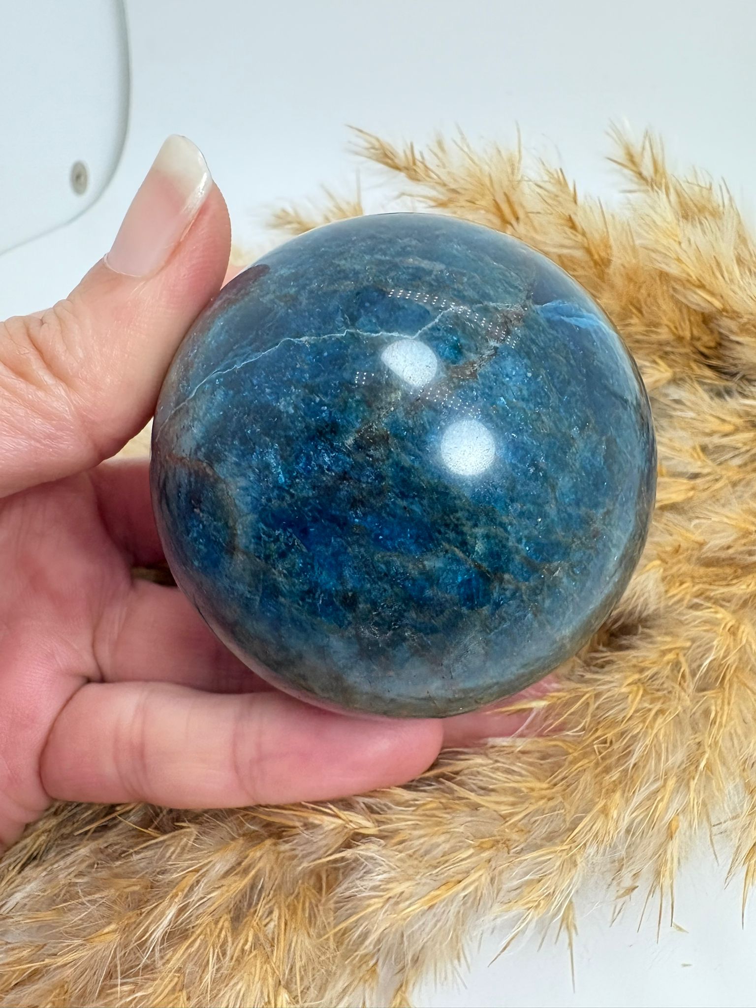 Esfera de apatito azul de 5,3 cm. Mineral asociado a la claridad mental, la comunicación y la expansión de la energía personal. Ideal para acompañarte en tu crecimiento interior.