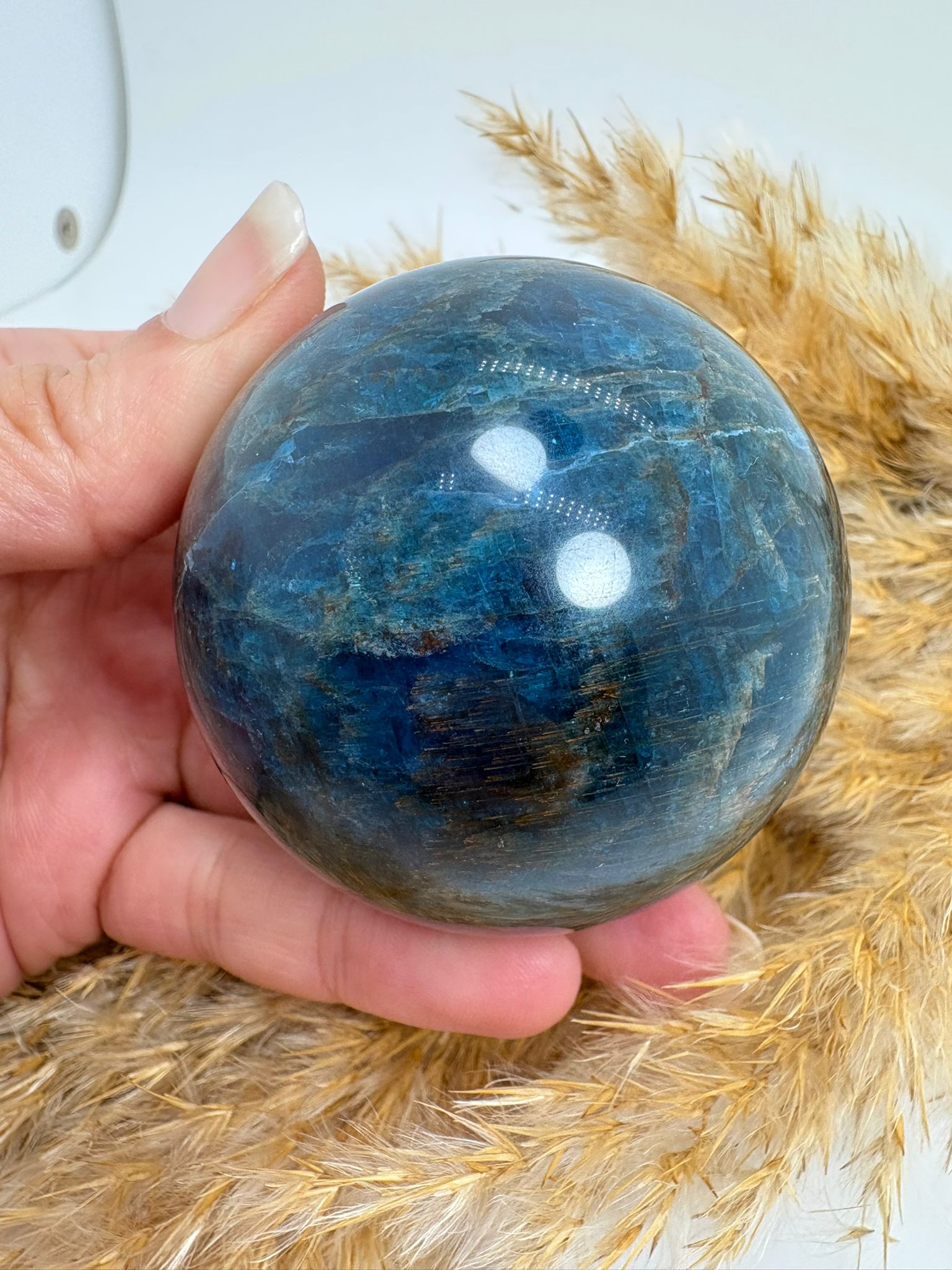 Esfera de apatito azul de 5,3 cm. Mineral asociado a la claridad mental, la comunicación y la expansión de la energía personal. Ideal para acompañarte en tu crecimiento interior.