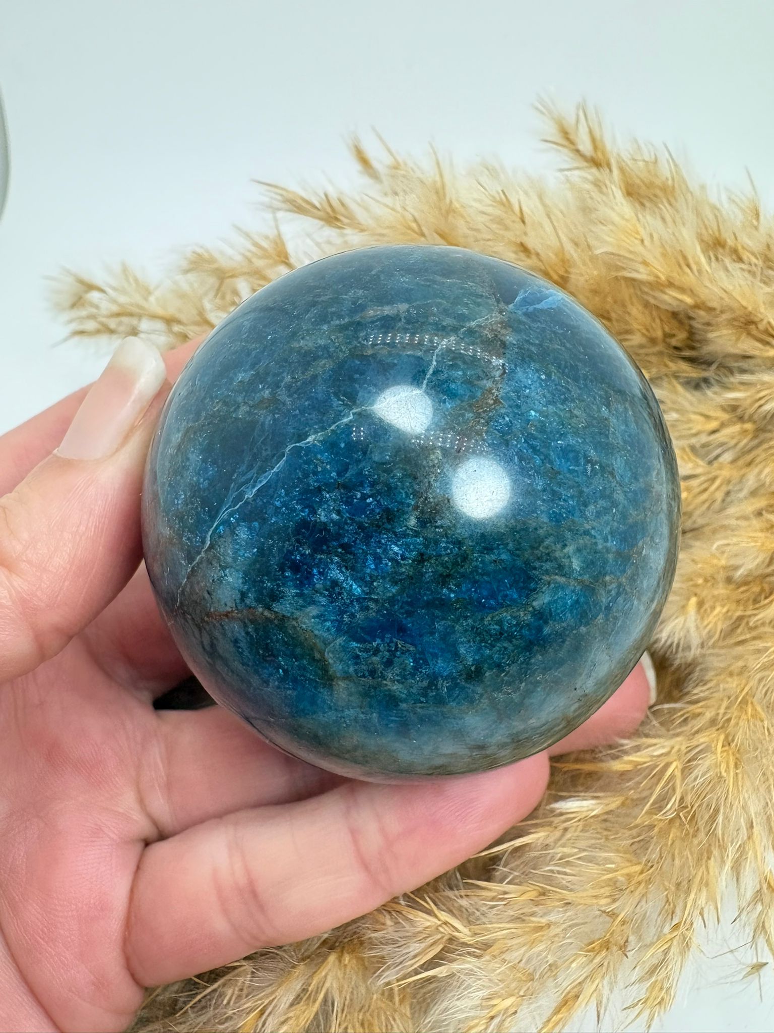 Esfera de apatito azul de 5,3 cm. Mineral asociado a la claridad mental, la comunicación y la expansión de la energía personal. Ideal para acompañarte en tu crecimiento interior.