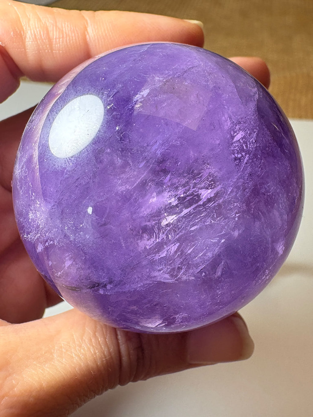 Esfera de amatista lila con zona ahumada y acabado pulido. Una pieza única para decorar o acompañar tu meditación en La Hada de las Piedras.