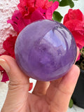 Esfera de amatista lila con zona ahumada y acabado pulido. Una pieza única para decorar o acompañar tu meditación en La Hada de las Piedras.