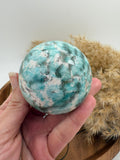 Esfera de amazonita con cuarzo ahumado, combinación única de calma y protección energética. Ideal para armonizar el hogar, equilibrar emociones y aportar bienestar.