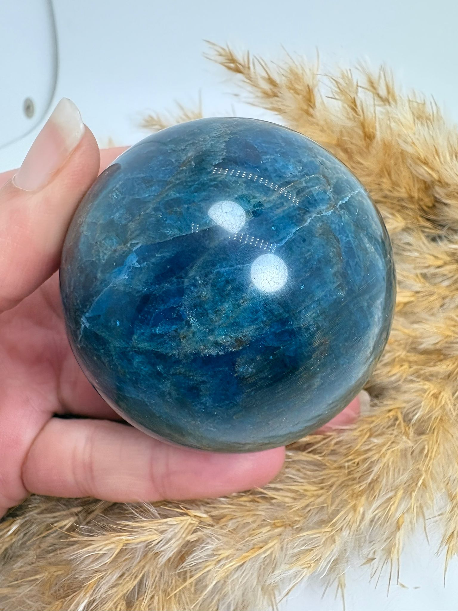Esfera de apatito azul de 5,3 cm. Mineral asociado a la claridad mental, la comunicación y la expansión de la energía personal. Ideal para acompañarte en tu crecimiento interior.