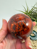 esfera de cornalina natural de tonos naranjas y rojizos, asociada con la vitalidad, la creatividad, la motivación y la confianza.