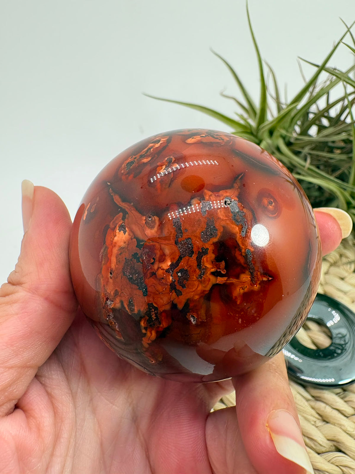 esfera de cornalina natural de tonos naranjas y rojizos, asociada con la vitalidad, la creatividad, la motivación y la confianza.