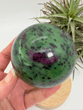 Esfera de zoisita con rubí, de muy buena calidad y pulido. 

El rubí reacciona a la luz uv.

La esfera de zoisita con rubí es una piedra natural que tiene propiedades energéticas muy interesantes. La zoisita es una piedra que se utiliza para equilibrar y armonizar las energías del cuerpo, mientras que el rubí es una piedra que se utiliza para estimular la vitalidad y la pasión. 

Juntas, la zoisita y el rubí crean una combinación única que puede ayudar a aumentar la energía, mejorar la concentración y la cr