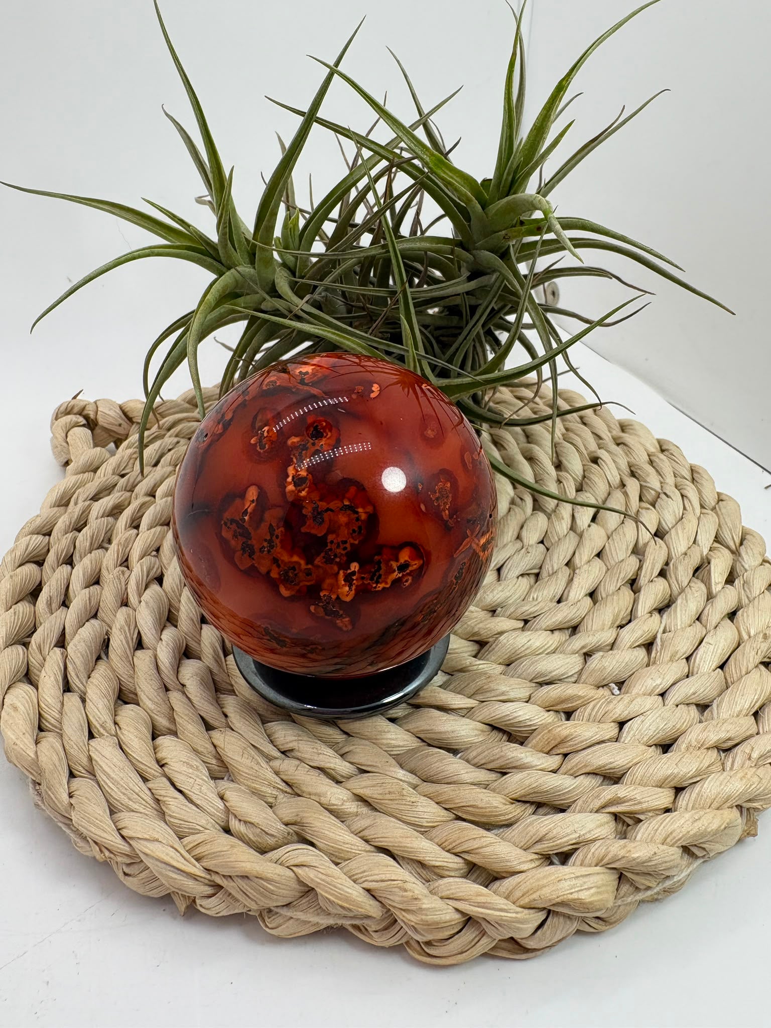 esfera de cornalina natural de tonos naranjas y rojizos, asociada con la vitalidad, la creatividad, la motivación y la confianza.