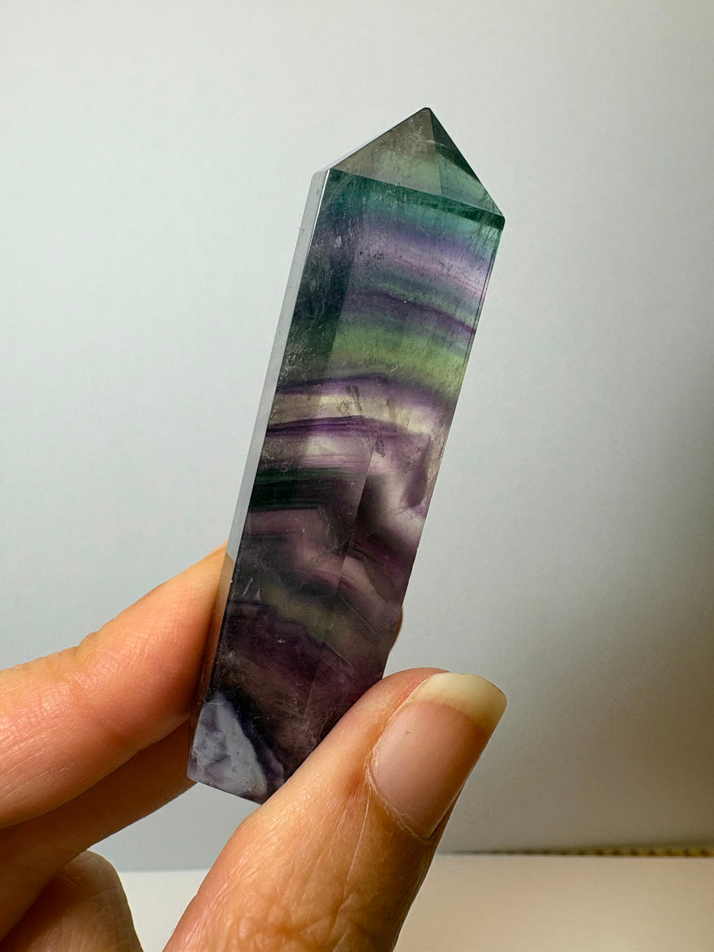 Punta de fluorita arcoíris natural pulida de 6 × 1,5 cm. Pieza única con hermosas bandas de color, ideal para colección, decoración o meditación