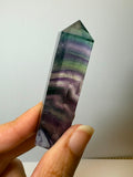 Punta de fluorita arcoíris natural pulida de 6 × 1,5 cm. Pieza única con hermosas bandas de color, ideal para colección, decoración o meditación