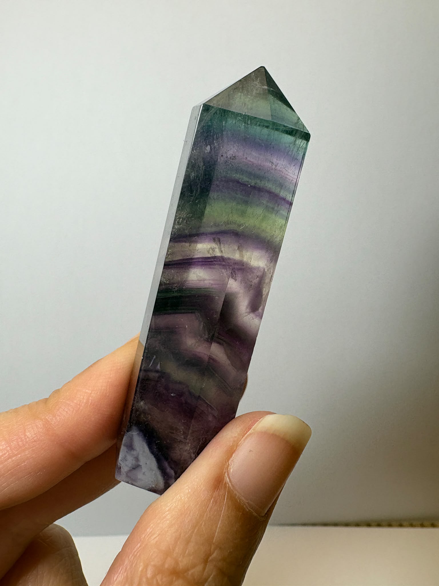 Punta de fluorita arcoíris natural pulida de 6 × 1,5 cm. Pieza única con hermosas bandas de color, ideal para colección, decoración o meditación