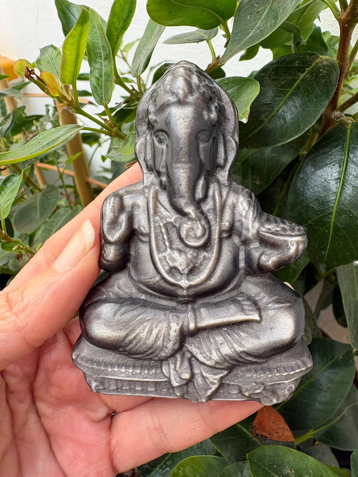 Descubre este Ganesha de obsidiana plateada tallado a mano de 7,7 cm. Una figura de bellos reflejos, ideal para decorar, meditar o regalar.