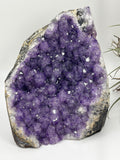 Geoda de amatista natural violeta intensa de 13,2 cm. Pieza única con cristales brillantes ideal para decoración y colección.