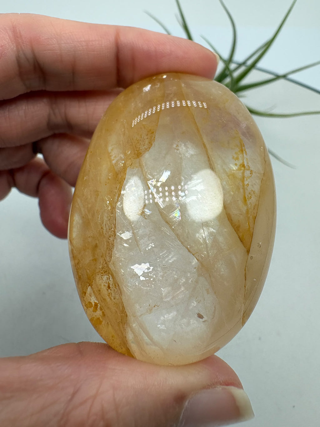 Palmstone de cuarzo hematoide de gran calidad y transparencia. Su interior presenta preciosas inclusiones en tonos anaranjados, rojizos y dorados, acompañadas de dibujos oscuros que forman un paisaje único dentro del cuarzo.