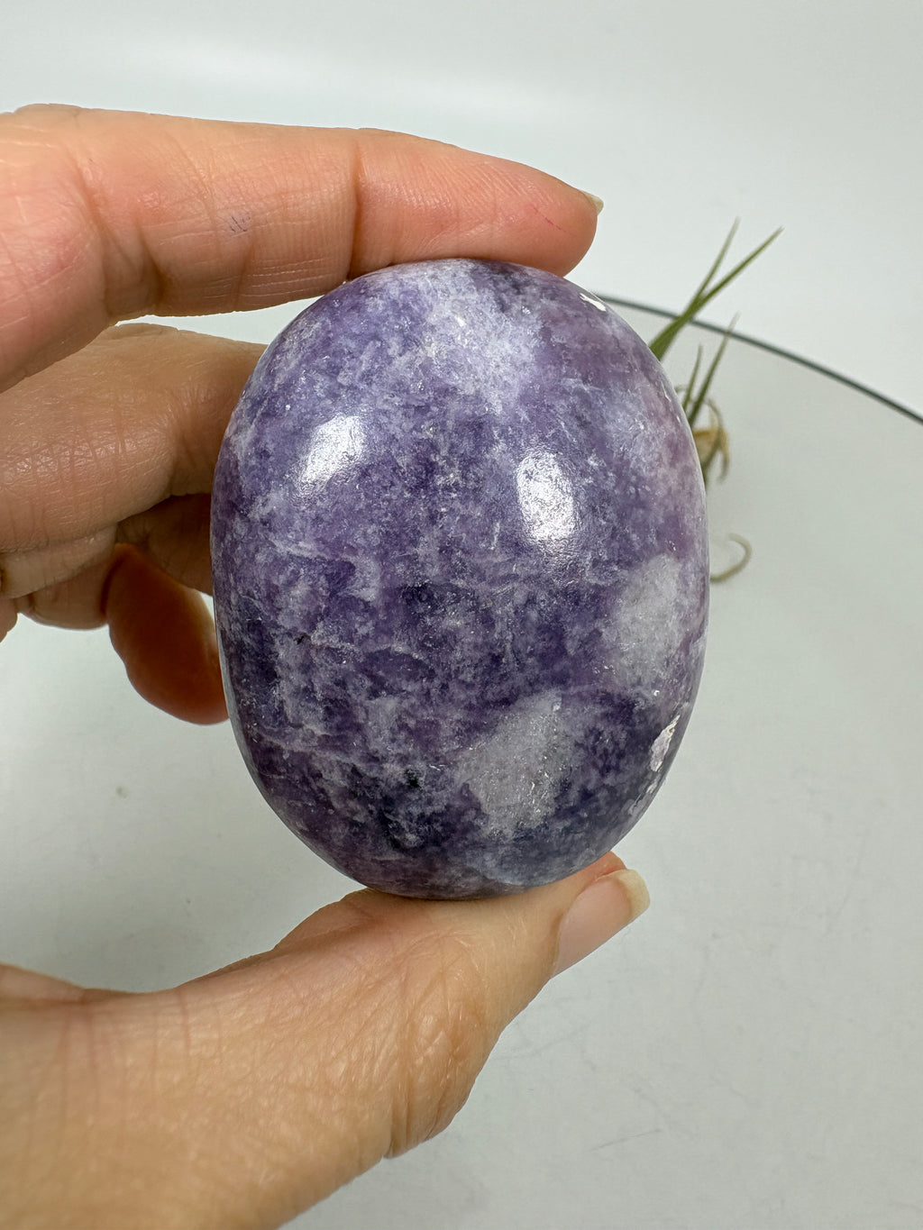Palmstone ovalado de lepidolita pulida con tonos violetas y zonas claras