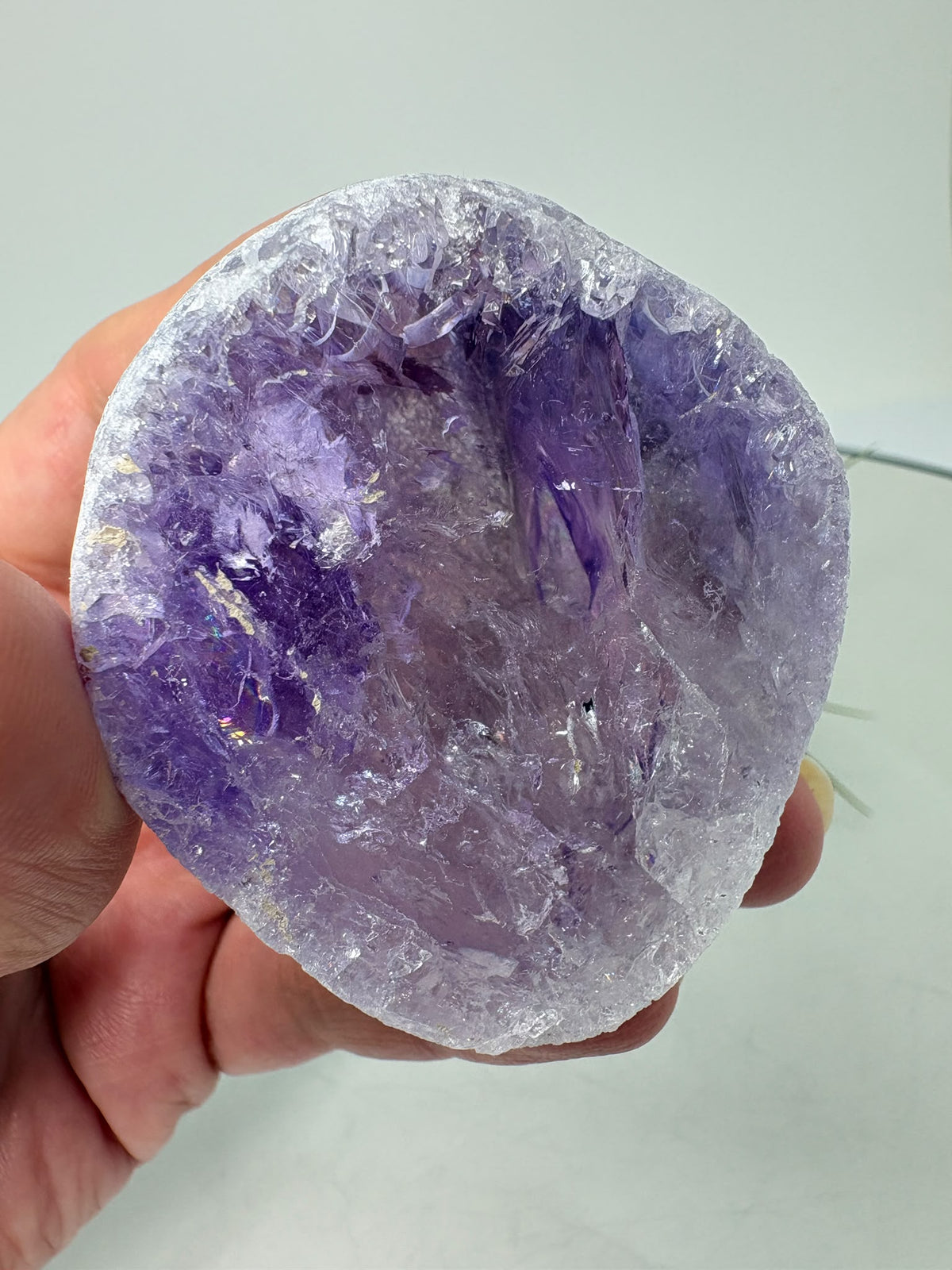 Amatista visión ahumada de gran calidad, con tonos violetas, zonas transparentes y pequeños destellos arcoíris. Descúbrela en La Hada de las Piedras.
