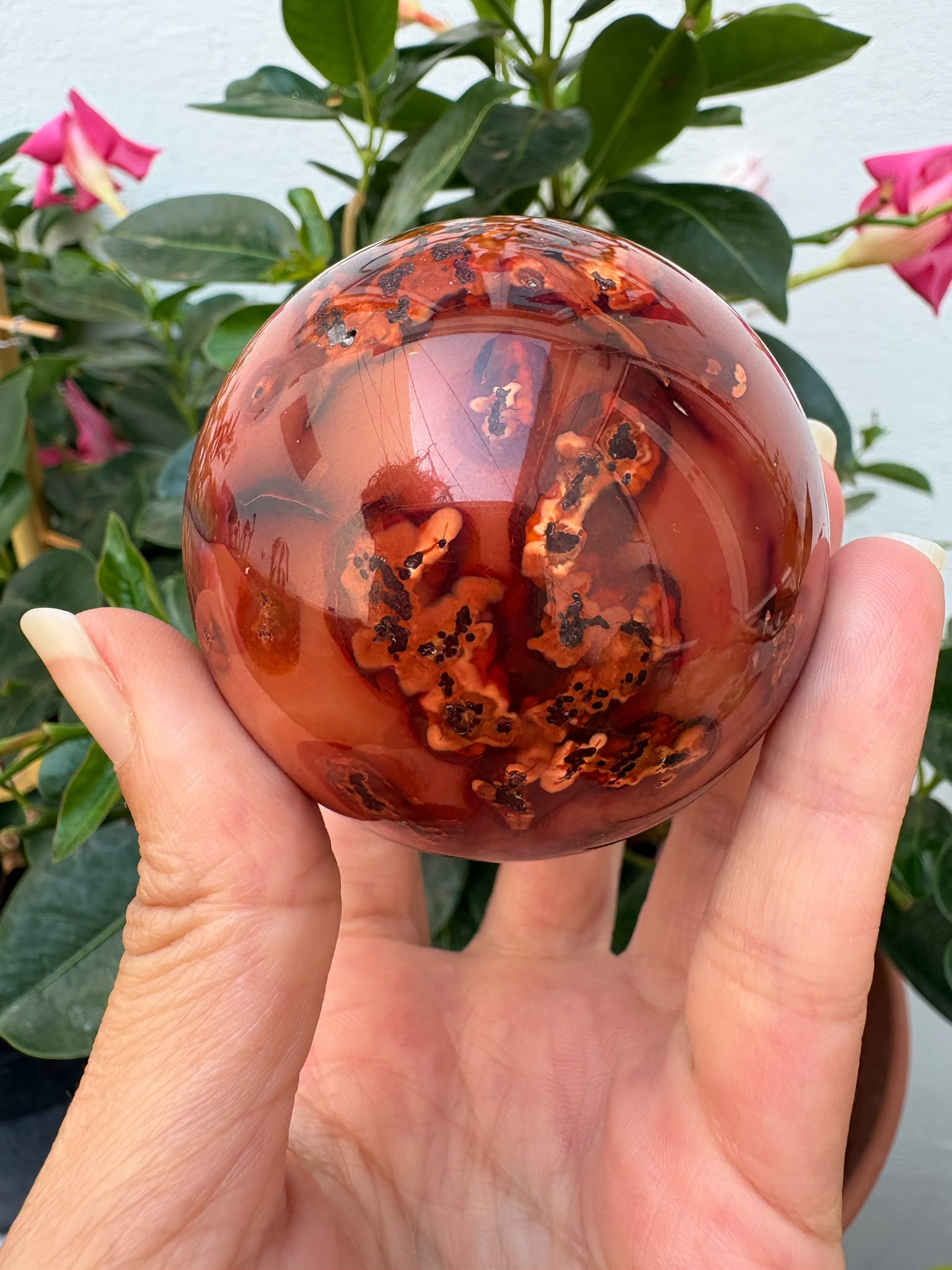 esfera de cornalina natural de tonos naranjas y rojizos, asociada con la vitalidad, la creatividad, la motivación y la confianza.
