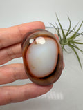 Ágata Sardónice natural de Madagascar, pulida y de pieza única. Descubre sus elegantes bandas naturales y añade un mineral exclusivo a tu colección.