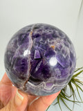 Esfera de amatista africana natural de 6,9 cm. Pieza única de intensos tonos violetas, ideal para colección, decoración, meditación y armonización de espacios. La base no está incluida.