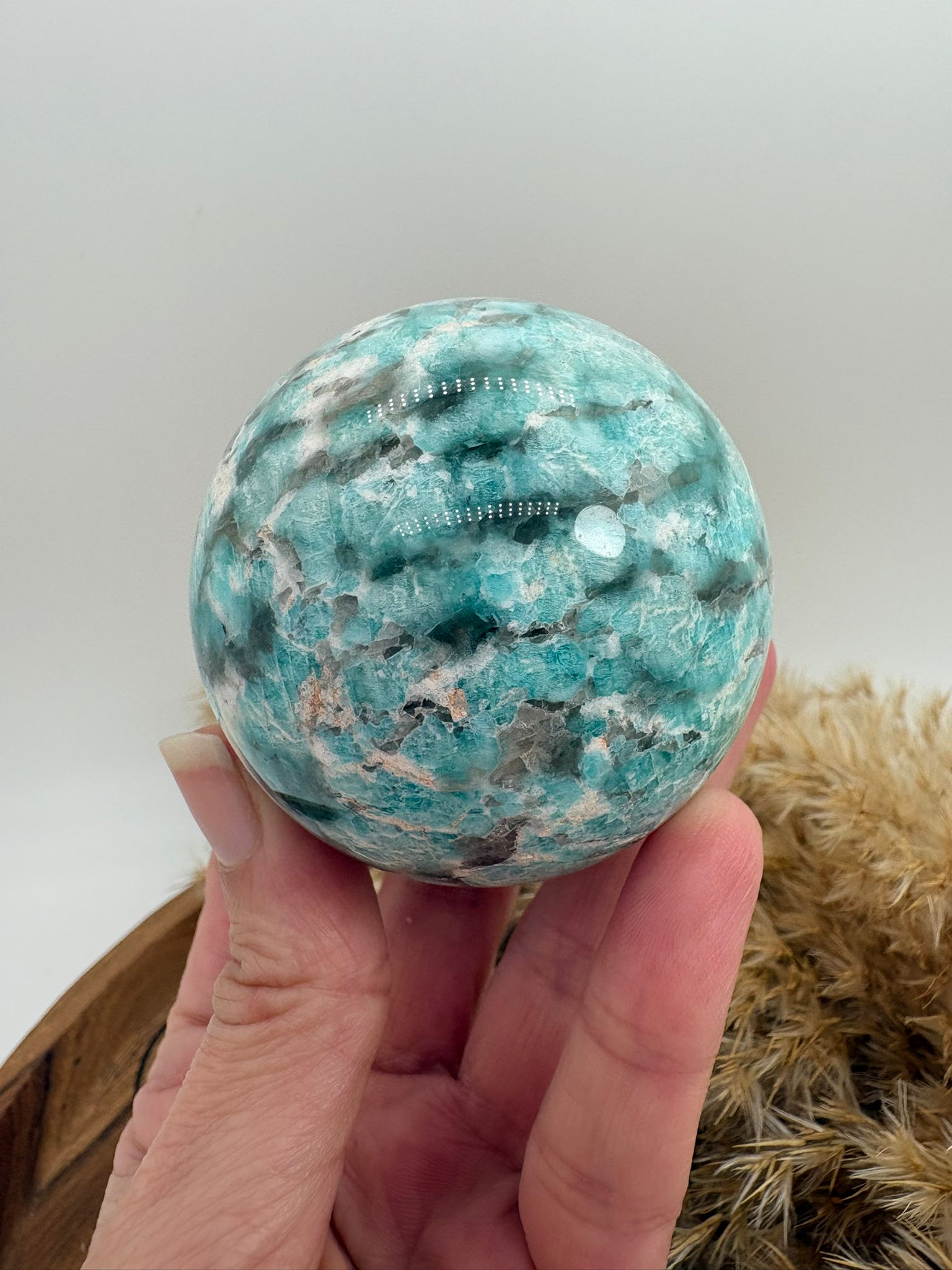 Esfera de amazonita con cuarzo ahumado, combinación única de calma y protección energética. Ideal para armonizar el hogar, equilibrar emociones y aportar bienestar.