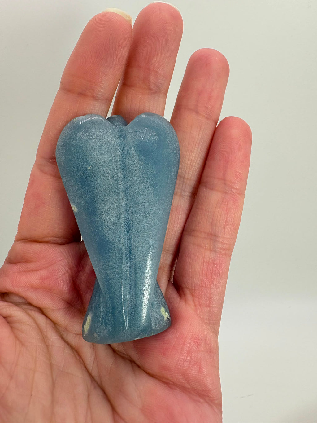 Ángel tallado en angelita natural de 5,3 × 3 cm. Pieza única de suave color azul, ideal para meditación, decoración y colección.