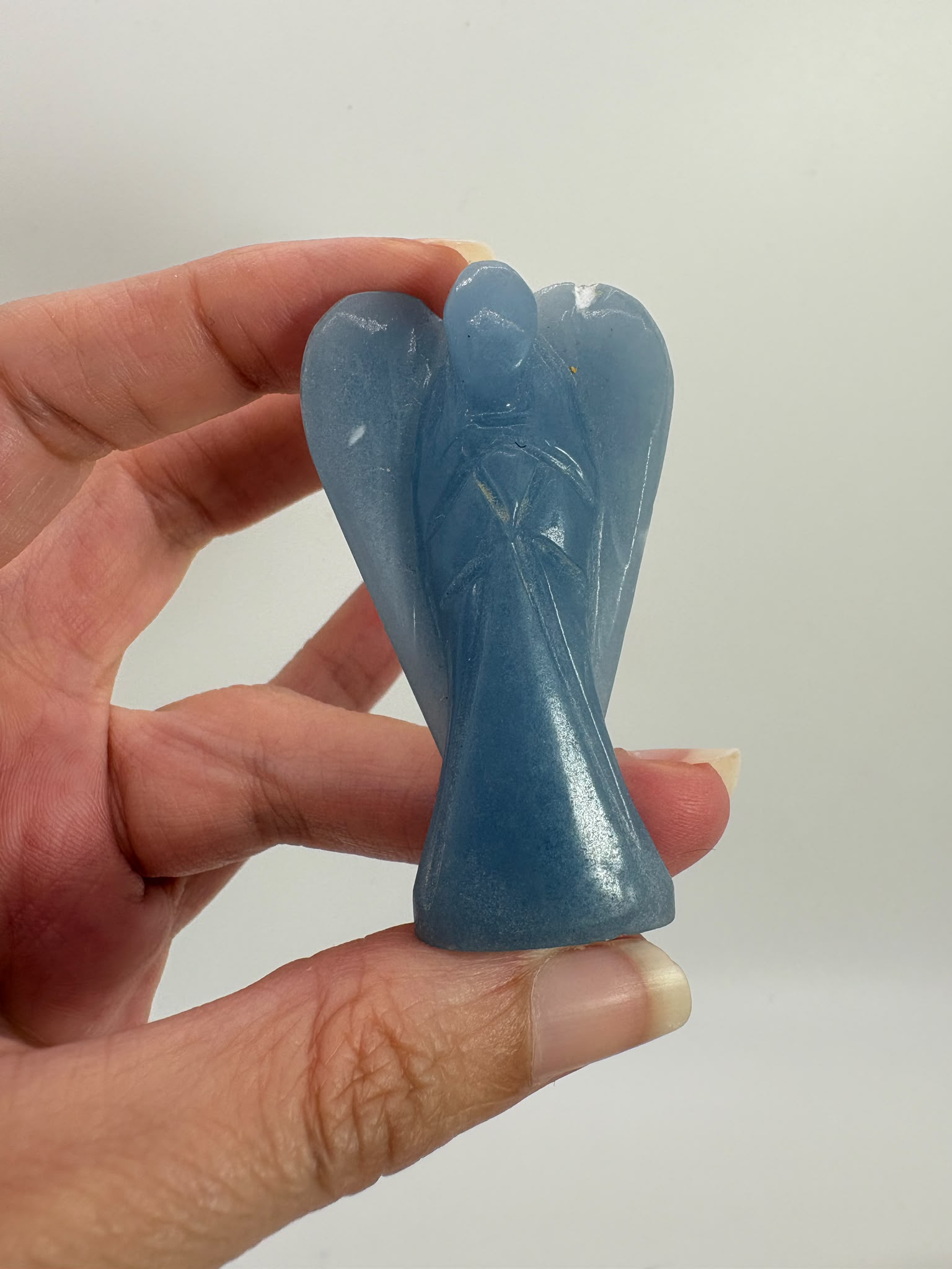 Ángel tallado en angelita natural de 5,3 × 3 cm. Pieza única de suave color azul, ideal para meditación, decoración y colección.
