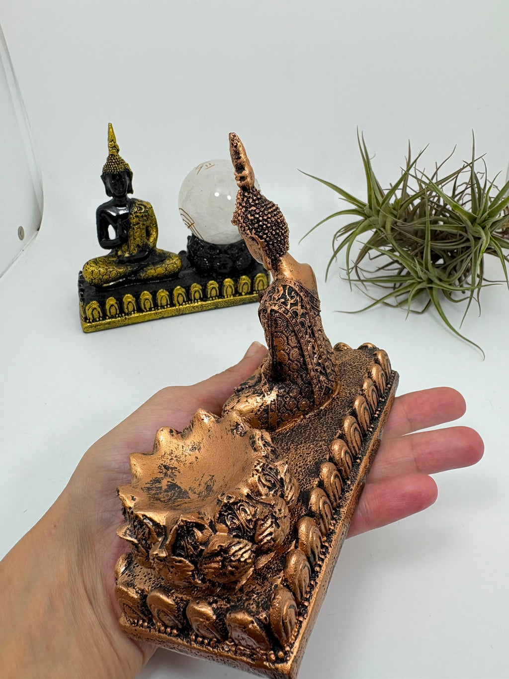 Porta esferas de Buda en resina, disponible en acabado dorado o cobre. Un soporte decorativo de inspiración oriental para colocar tus esferas