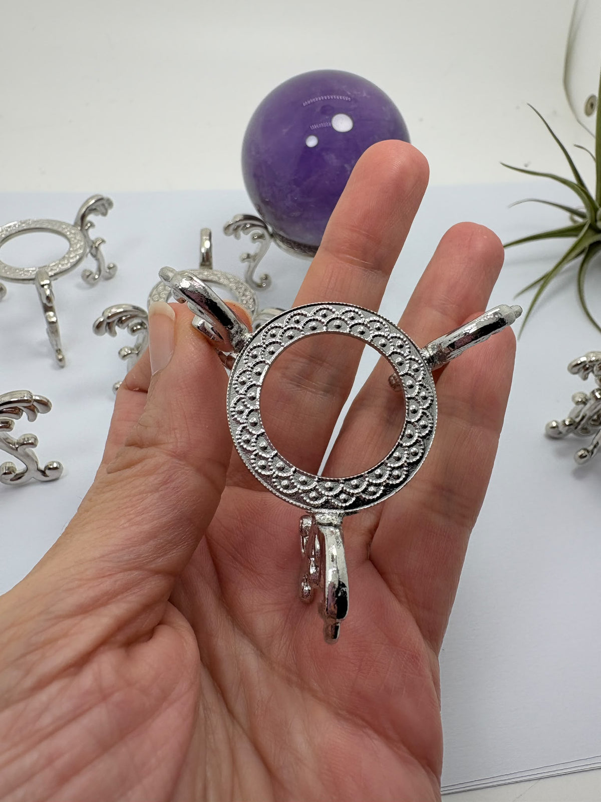 Realza tus esferas de minerales con esta base de metal plateado de diseño decorativo. Ideal para presentar esferas medianas y grandes con elegancia.