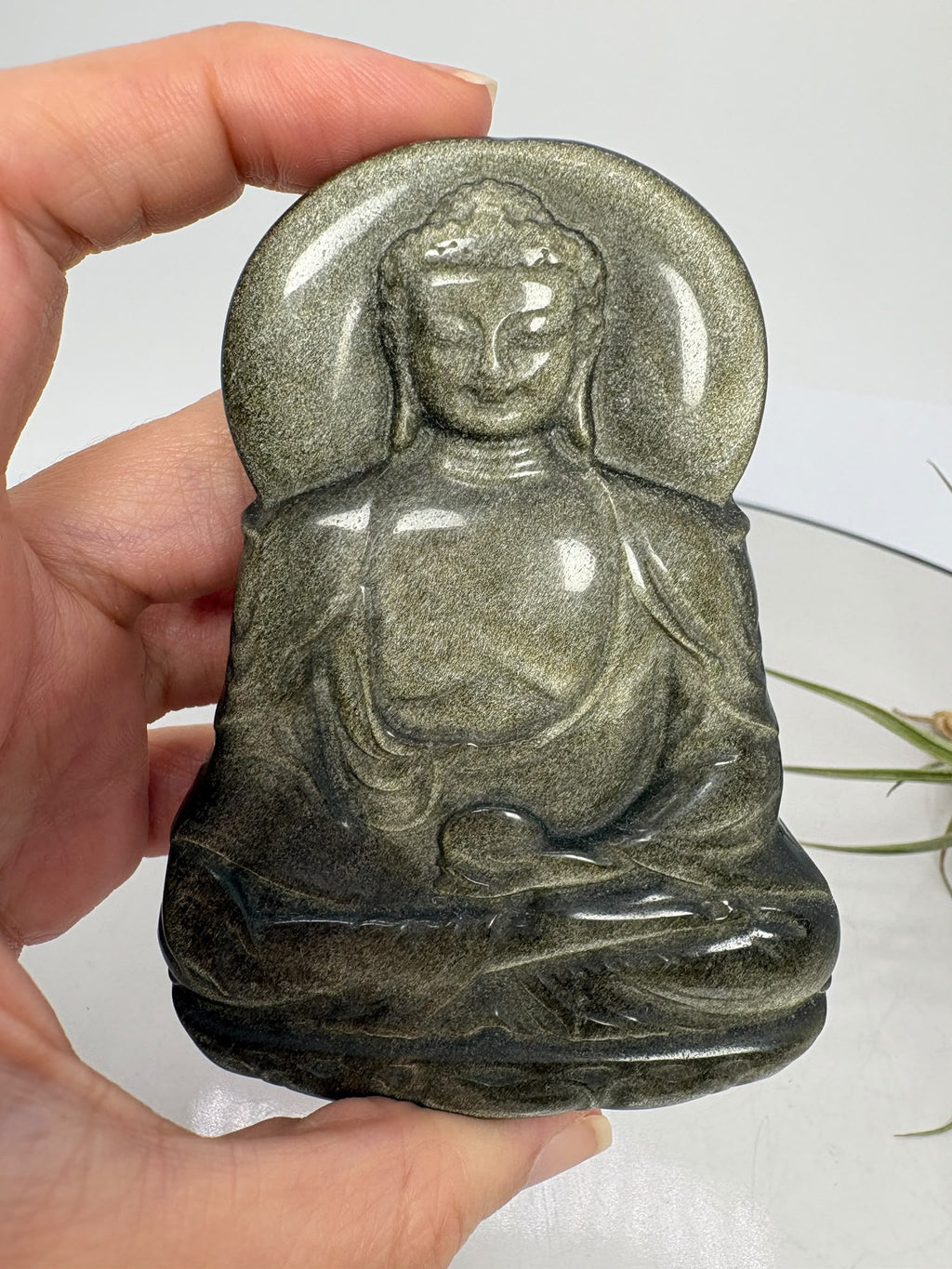 Buda de obsidiana plateada tallado a mano de 8,1 cm. Piezas escogidas con dedicación para regalar o meditar. Envío de una unidad aleatoria.