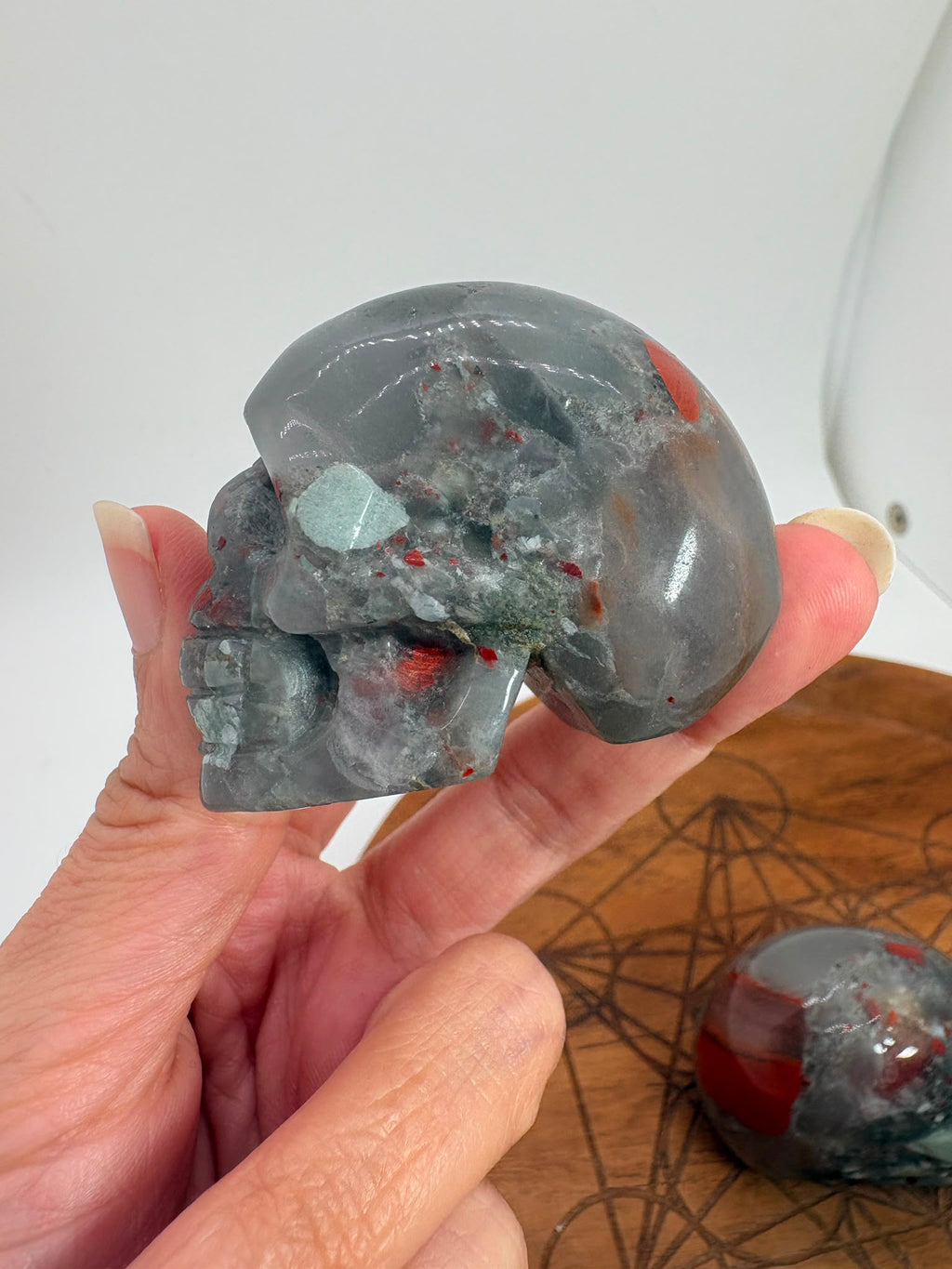 Calavera de jaspe heliotropo natural pulida. Mineral con tonos verdes e inclusiones rojizas. Ideal para colección, decoración o regalo especial.