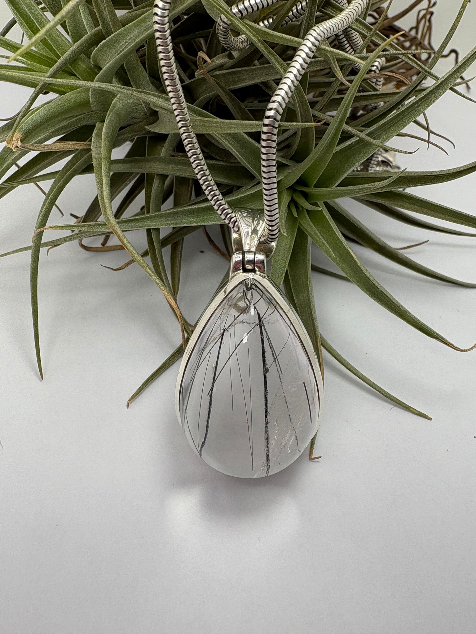 Colgante de cuarzo con turmalina negra en plata de ley. Piedra natural de alta calidad y gran transparencia. Joya única elegante y con carácter.
