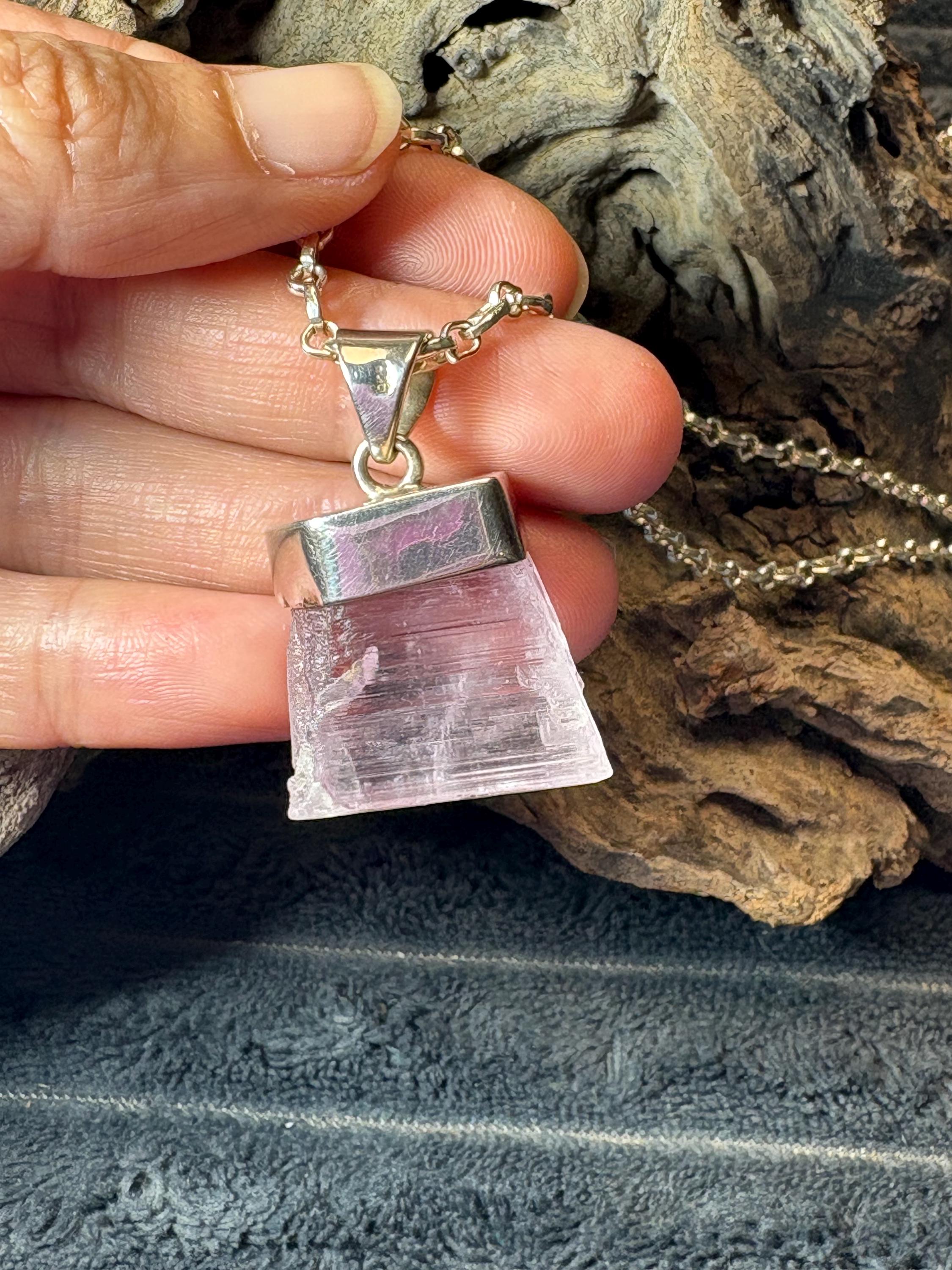 Colgante de kunzita natural en bruto en plata de ley. Piedra rosa asociada al amor, la calma y el equilibrio emocional. Joya con significado.