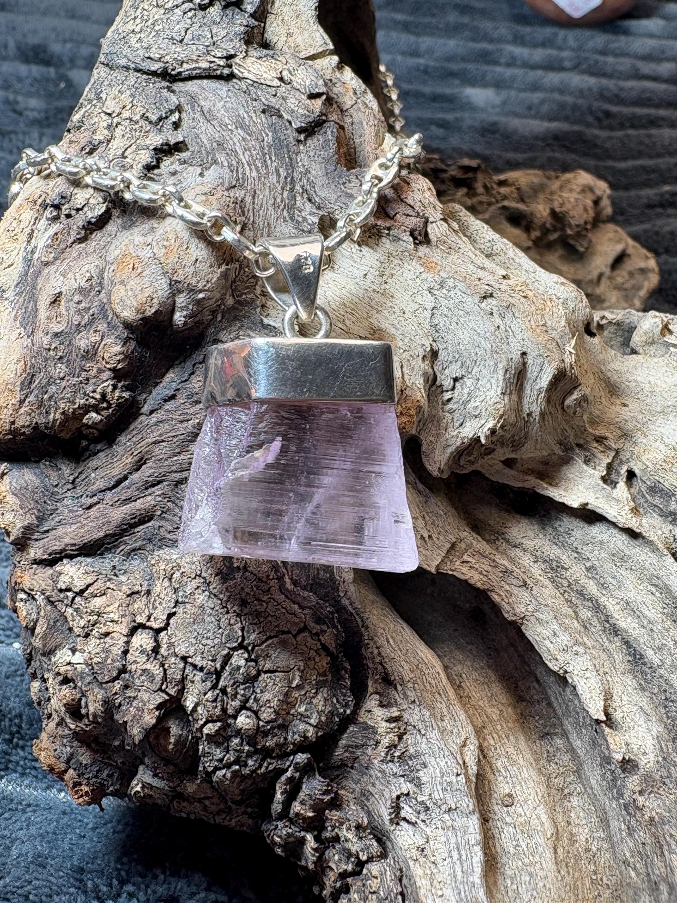 Colgante de kunzita natural en bruto en plata de ley. Piedra rosa asociada al amor, la calma y el equilibrio emocional. Joya con significado.