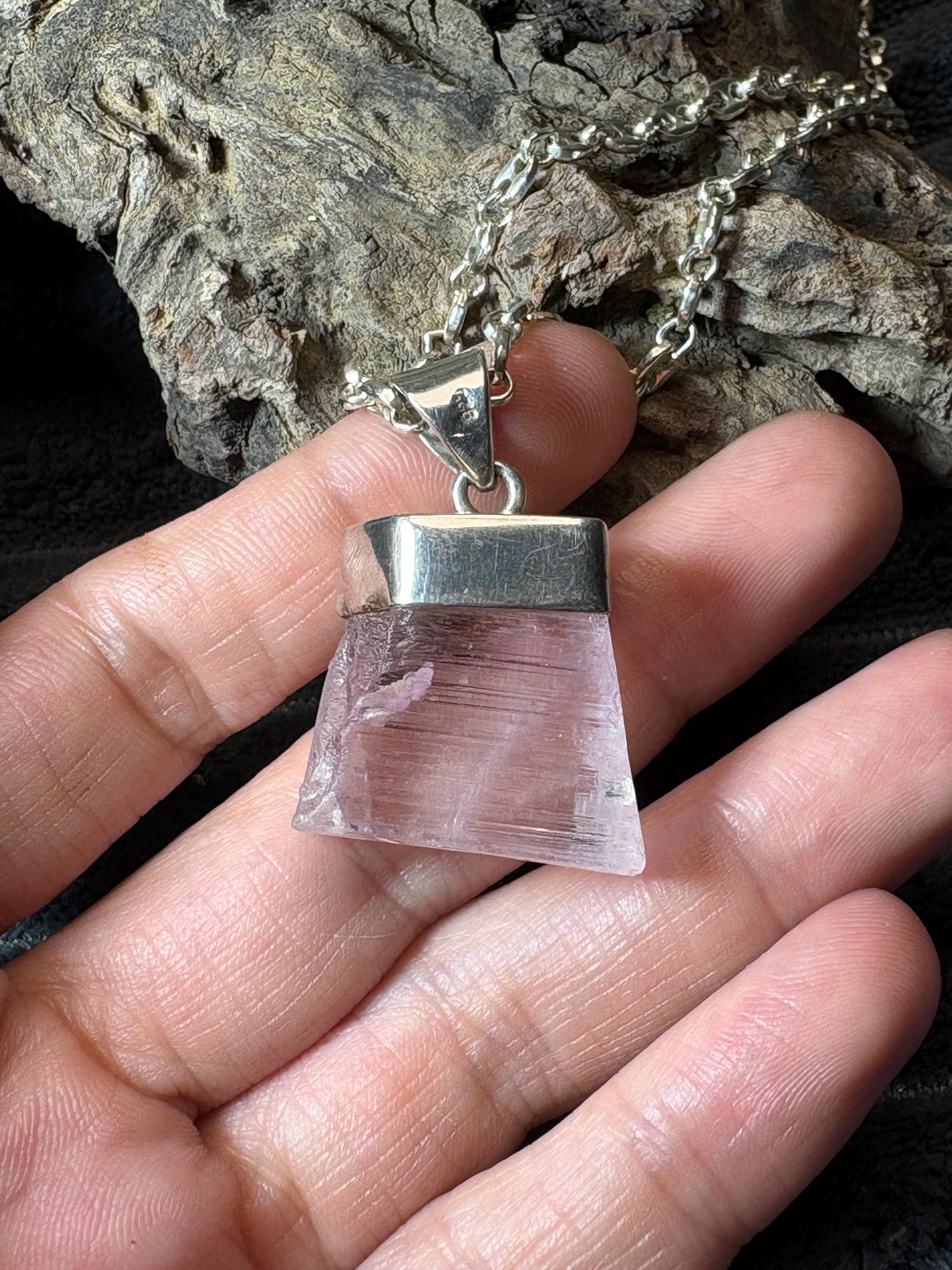Colgante de kunzita natural en bruto en plata de ley. Piedra rosa asociada al amor, la calma y el equilibrio emocional. Joya con significado.