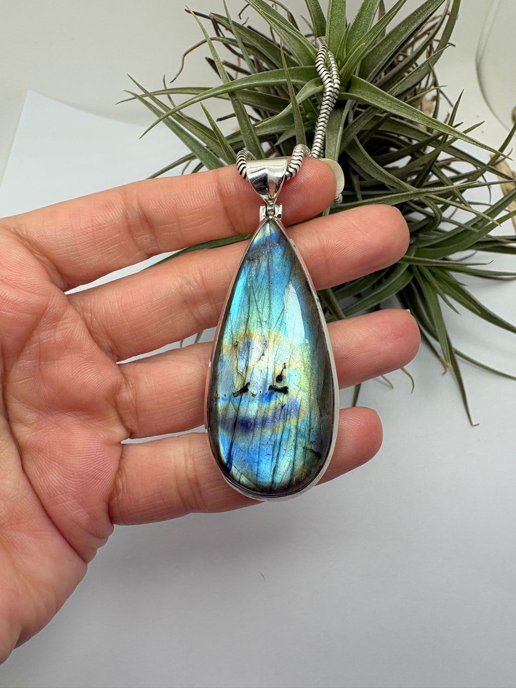 Colgante de labradorita en plata de ley con reflejos iridiscentes. Piedra natural única con tonos azules y verdes. Joya elegante y con carácter.Piedra espiritual de cambio y evolución.
