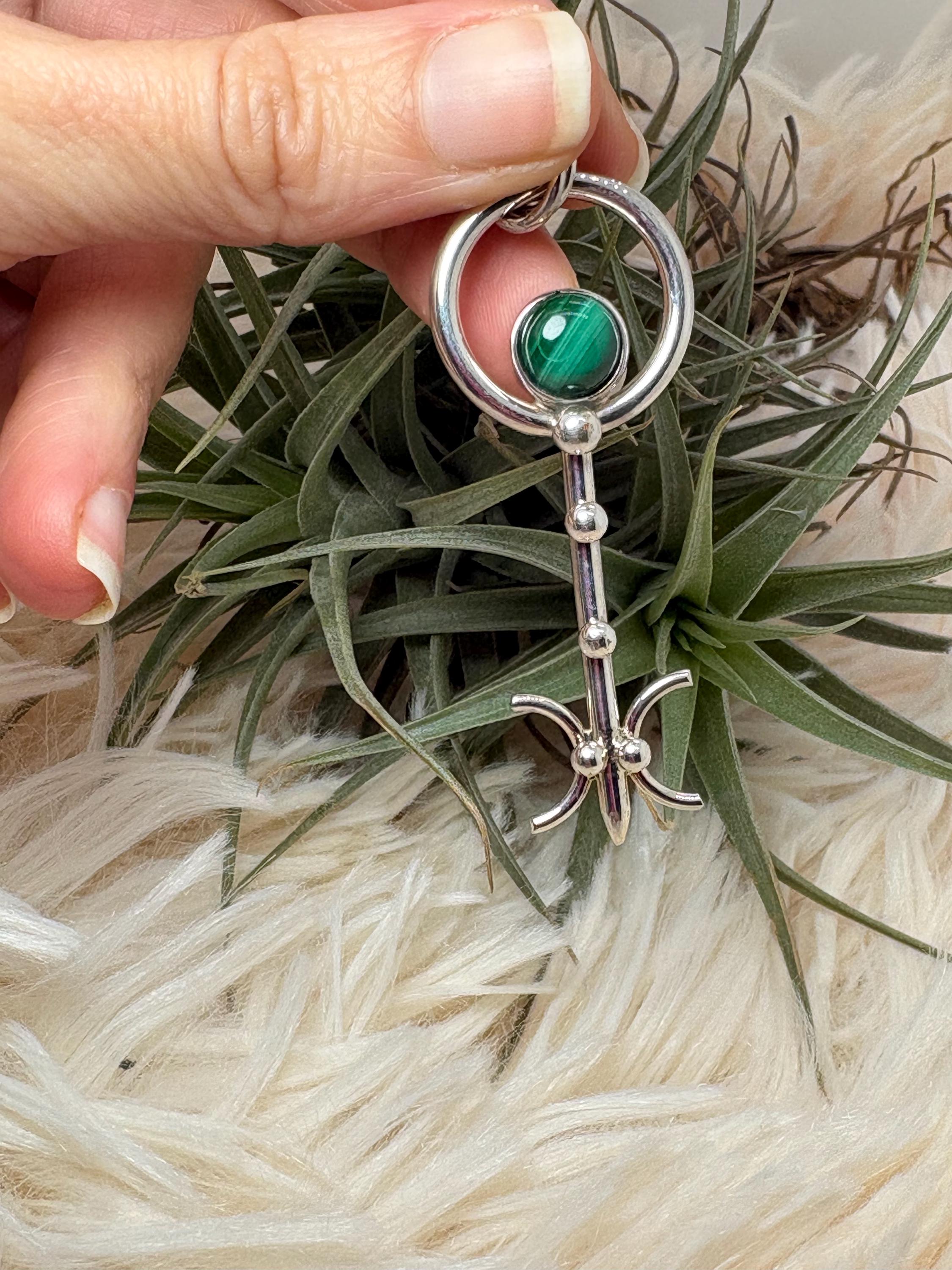 Colgante llave de malaquita en plata de ley artesanal. Joya con significado que abre caminos y favorece la transformación personal.