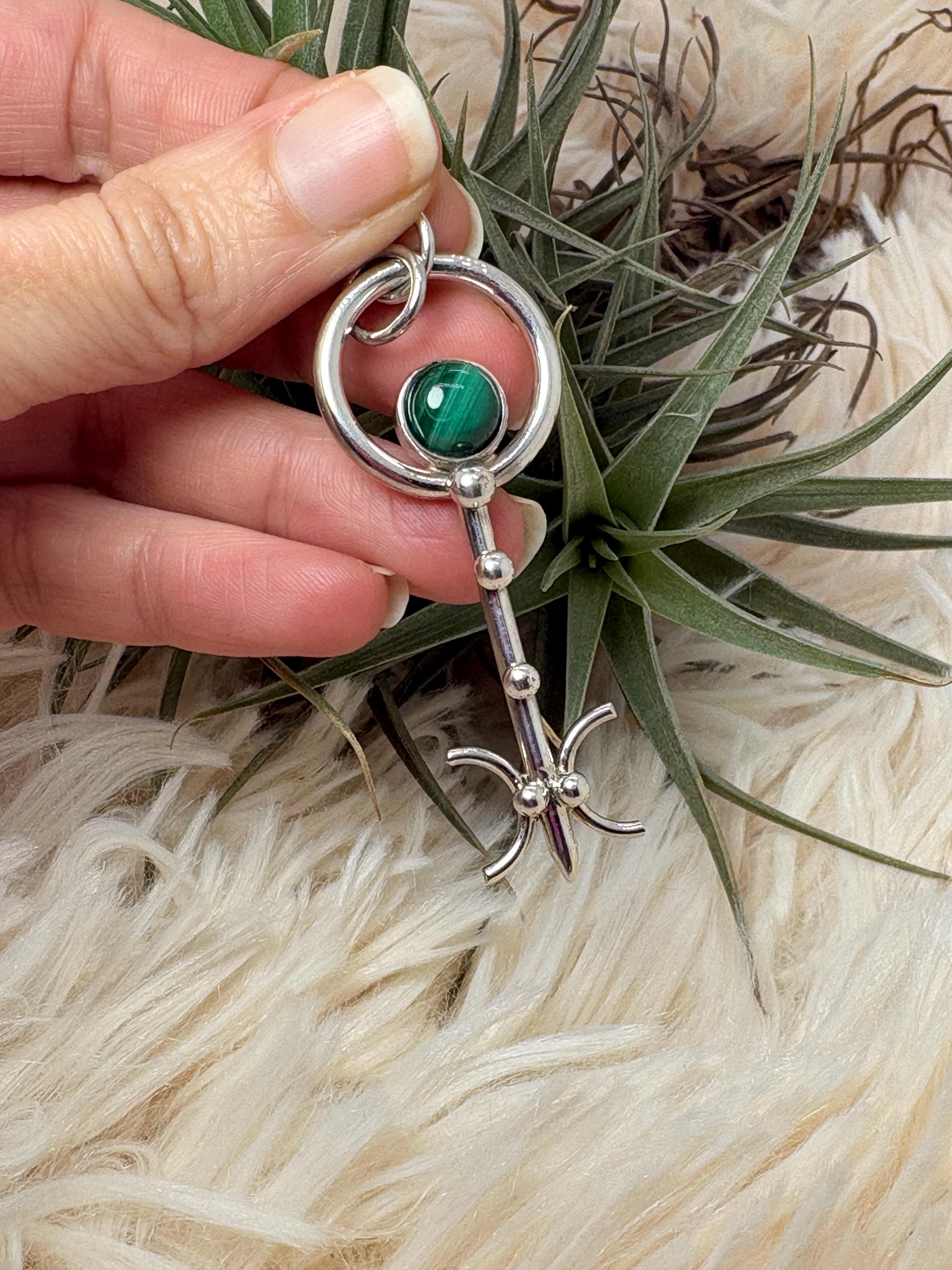 Colgante llave de malaquita en plata de ley artesanal. Joya con significado que abre caminos y favorece la transformación personal.