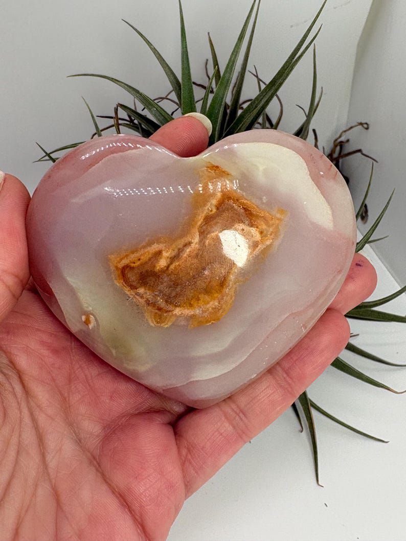 Corazón de ónix rosado con energía de calma, amor propio y equilibrio emocional. Pieza única ideal para armonizar espacios y acompañar procesos interiores.