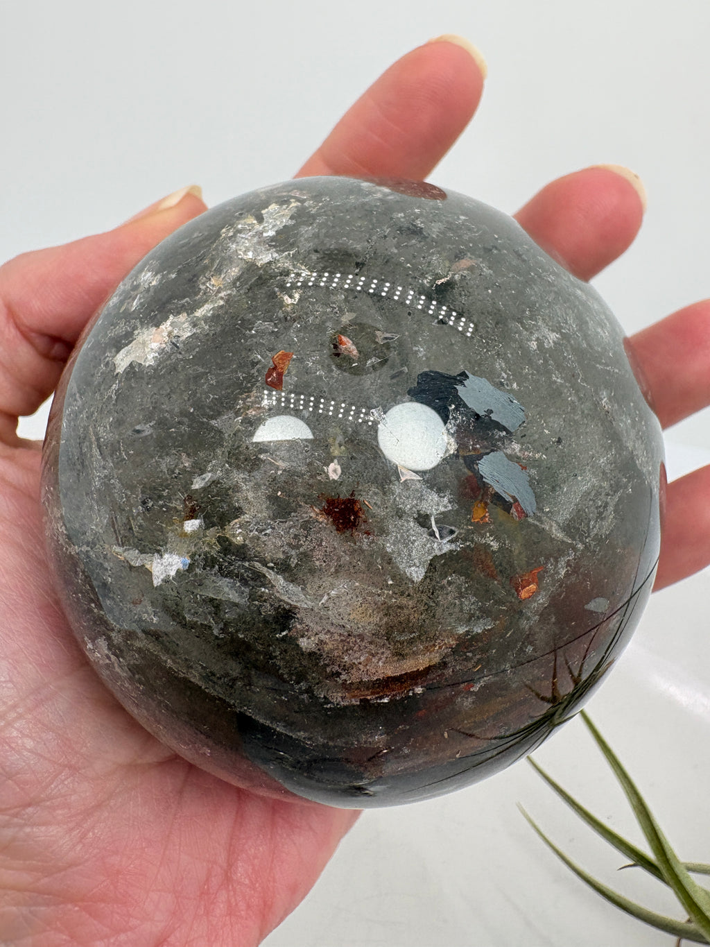 Impresionante esfera de cuarzo chamánico de gran tamaño, una pieza única llena de carácter y belleza natural.

Su interior presenta inclusiones, velos y fracturas naturales que crean espectaculares reflejos arcoíris al recibir la luz.