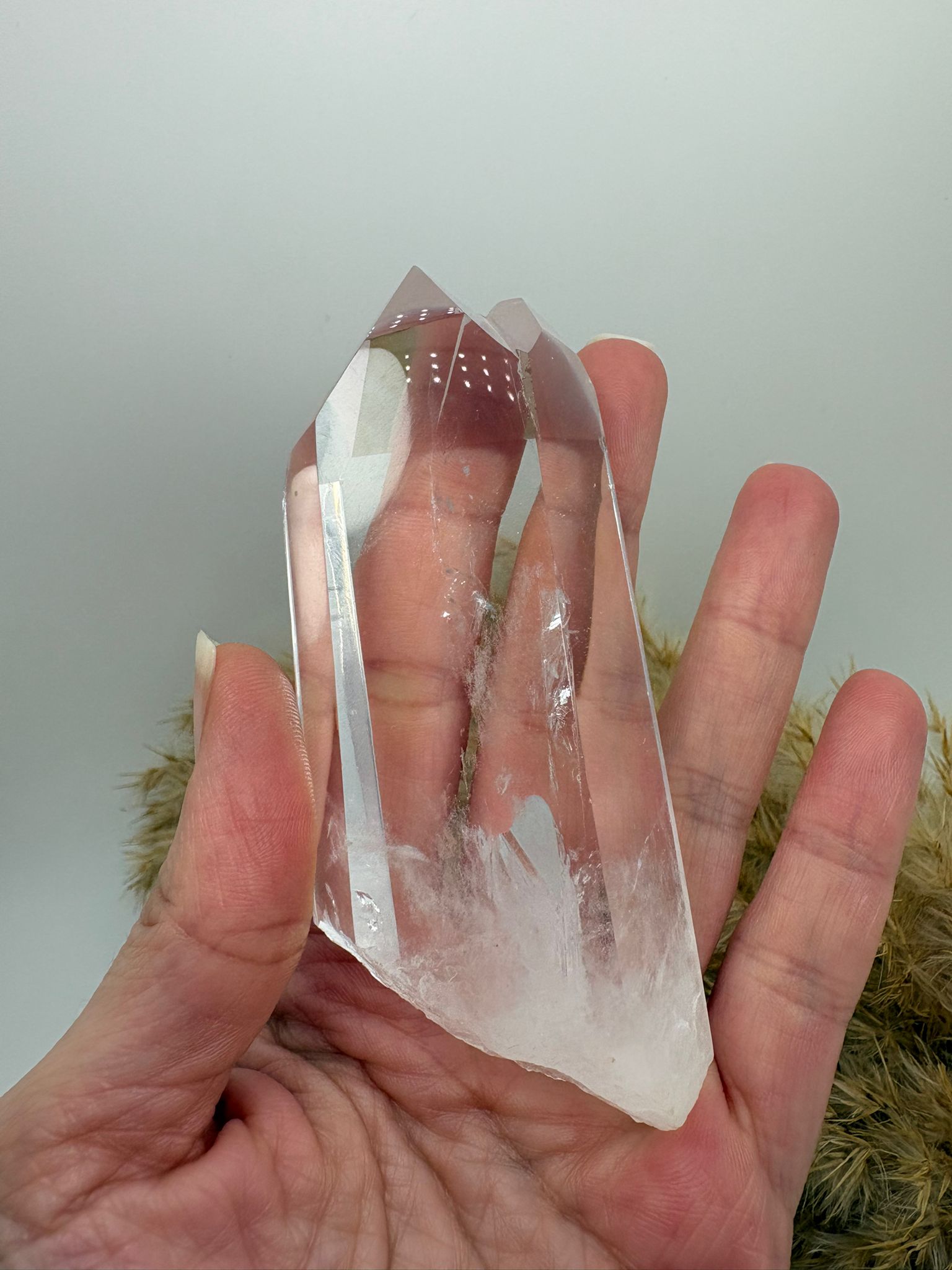 Cuarzo cristal natural pulido con zonas en bruto y arcoíris interno