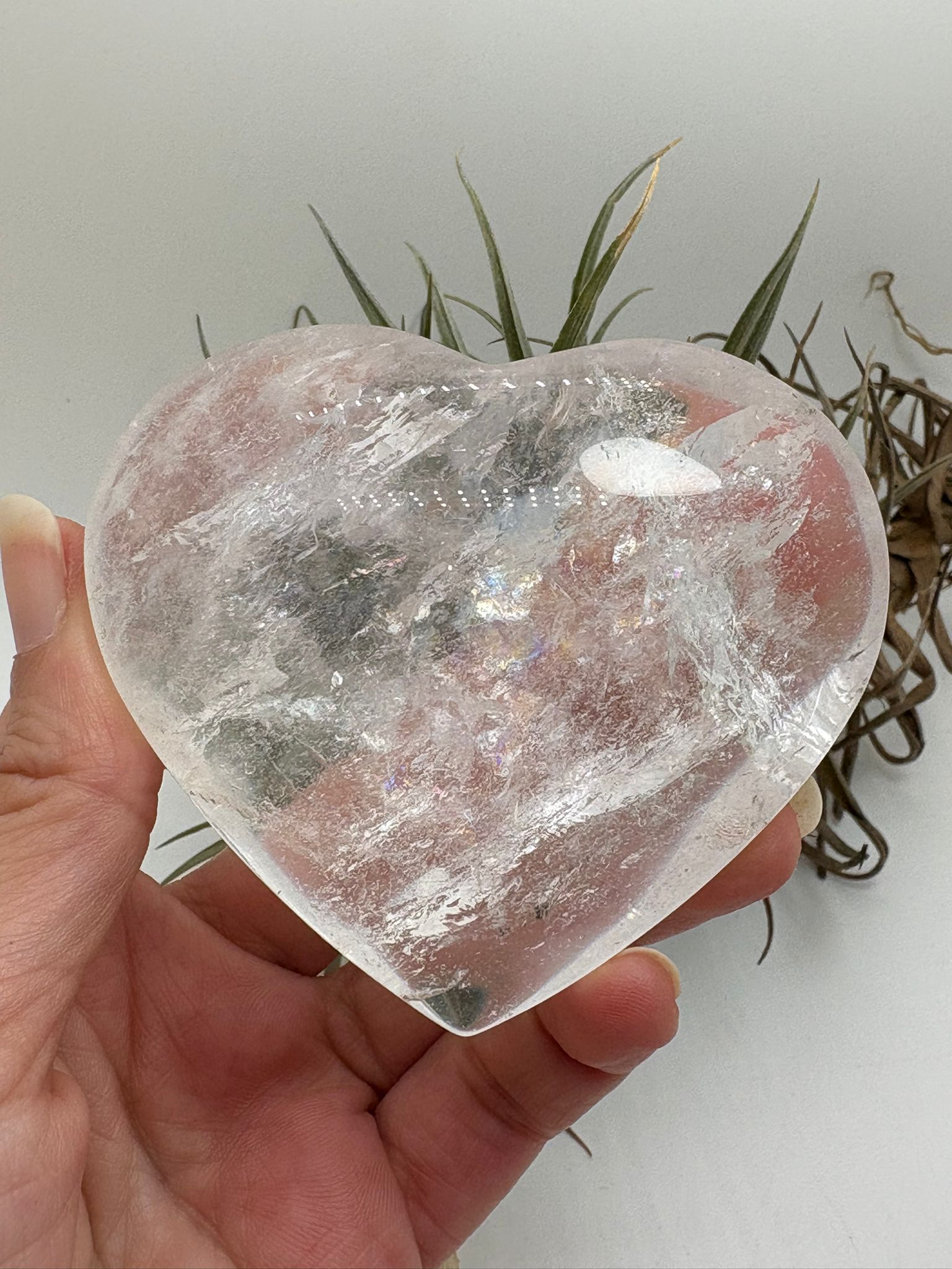 Corazón de cuarzo cristal transparente con preciosos reflejos arcoíris naturales en su interior. Una pieza pulida llena de luz y energía, ideal para decorar, meditar o trabajar la claridad mental y la armonía energética.